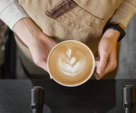 Top View of Our Female Barista Holding Cup of Coffee