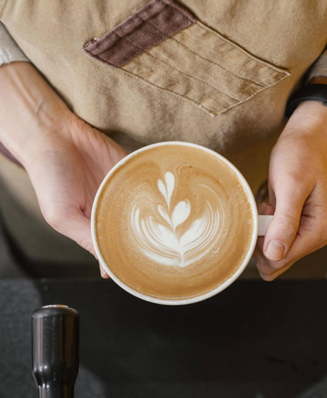 Top View of Our Barista Holding Cup of Coffee